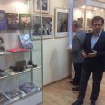 Андрей Диамент с посетителями выставки возле стенда с изданными им и его отцом фотокниг и альбомов с фотографиями Роберта Диамента
